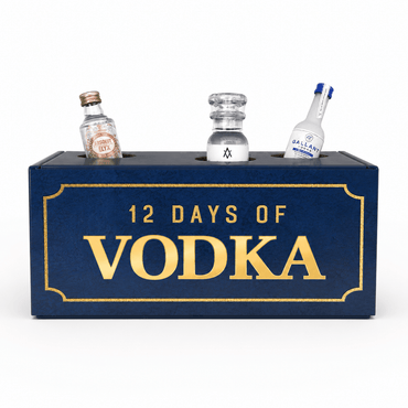 A dark blue rectangular box with gold lettering that reads '12 DAYS OF VODKA,' with three miniature clear bottles inserted into the top. The center bottle is empty, while the left and right bottles are labeled with vodka branding.