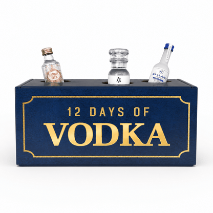 A dark blue rectangular box with gold lettering that reads '12 DAYS OF VODKA,' with three miniature clear bottles inserted into the top. The center bottle is empty, while the left and right bottles are labeled with vodka branding.