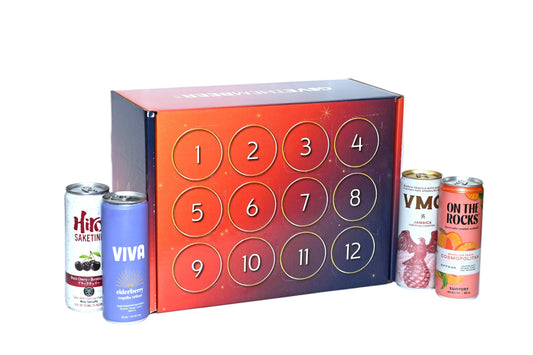 A beverage advent calendar box with 12 numbered circular doors in red, orange, and purple tones, displayed on a white surface with four beverage cans arranged around it against a white background.