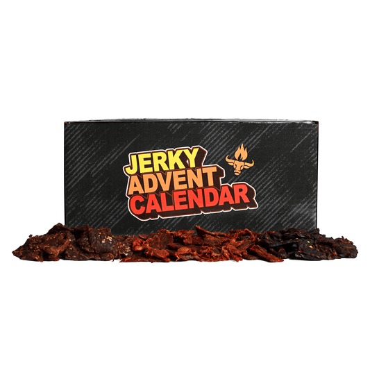 A black product box labeled 'JERKY ADVENT CALENDAR' with a small campfire logo, shown with a pile of dark red jerky slices in front on a white background.