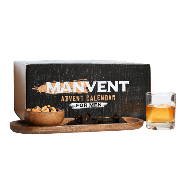 A Manvent Advent Calendar for Men gift set shown with its black branded box, a small bowl of nuts, jerky and glass of whiskey