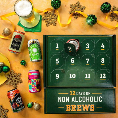 An advent-style beer box labeled '12 DAYS OF NON ALCOHOLIC BREWS' sits on a warm tan surface with festive props. The dark green numbered box has one can partially pulled out.