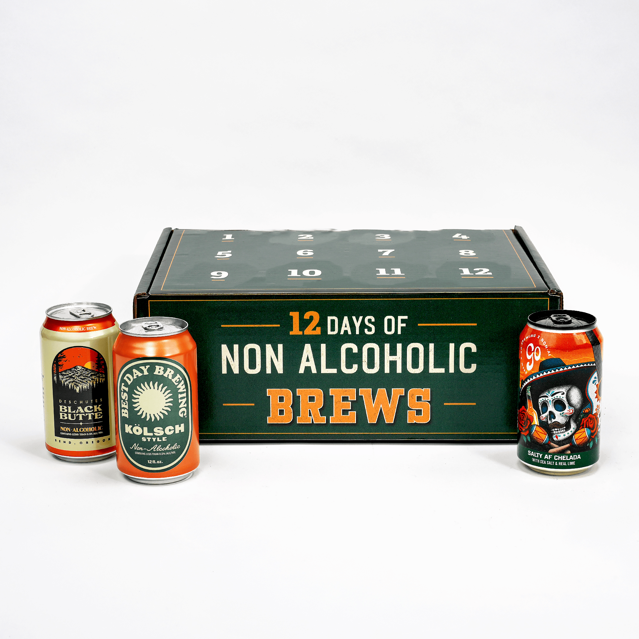 A 12-day non-alcoholic beer subscription box set displayed on a white background, featuring a dark green box labeled '12 DAYS OF NON ALCOHOLIC BREWS' with three sample beverage cans in front: Black Bliss, Kolsch, and Day of the Dead.