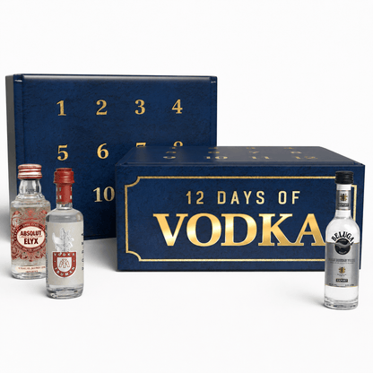 A 12-day vodka advent calendar set featuring a navy blue box with gold lettering and numbers, alongside three miniature vodka bottles including Absolut Elyx, Smirnoff, and Calvets, on a white background.