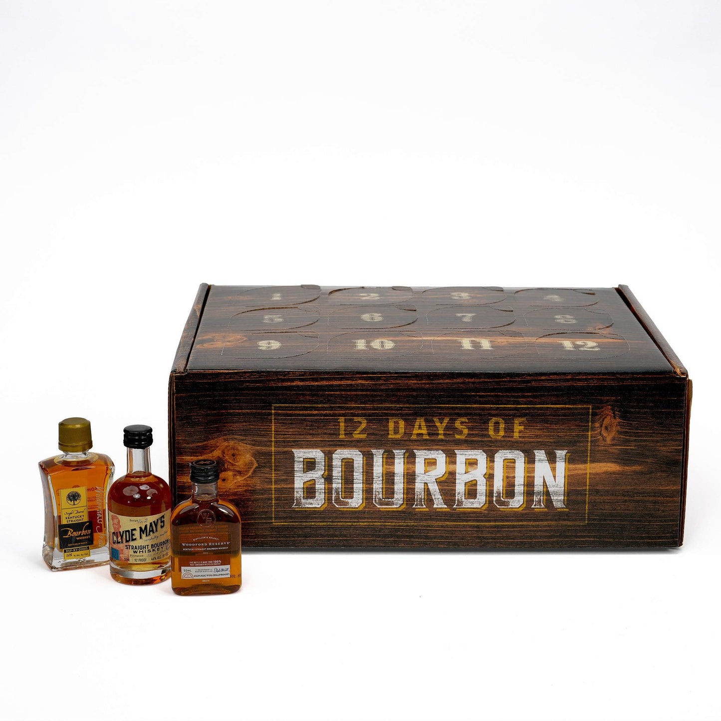 A 12-day bourbon whiskey advent calendar with three small bottles of bourbon whiskey placed in front on a white background.