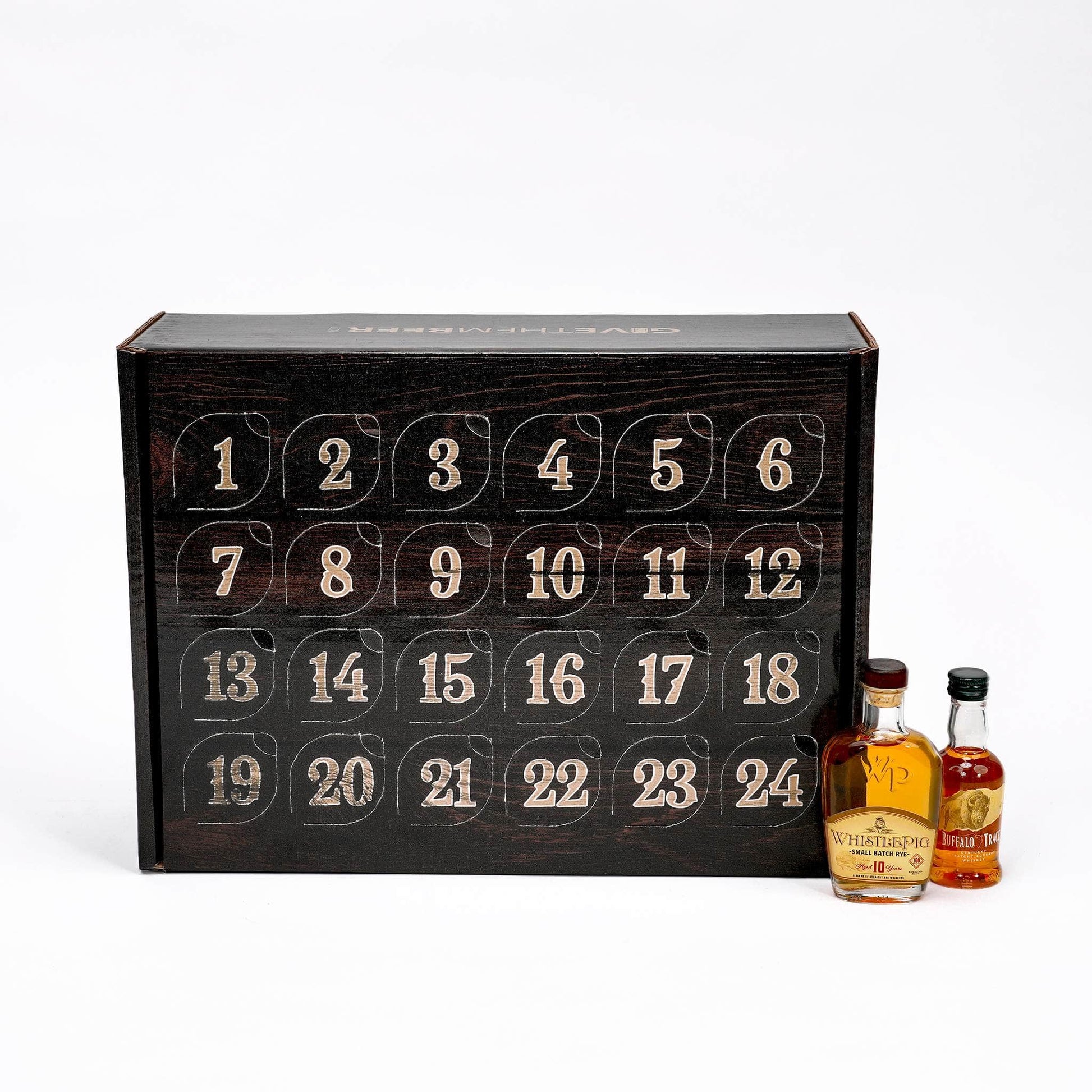 A 24-door whisky advent calendar box with numbered compartments, shown open with two miniature bottles of whisky in front on a white background.